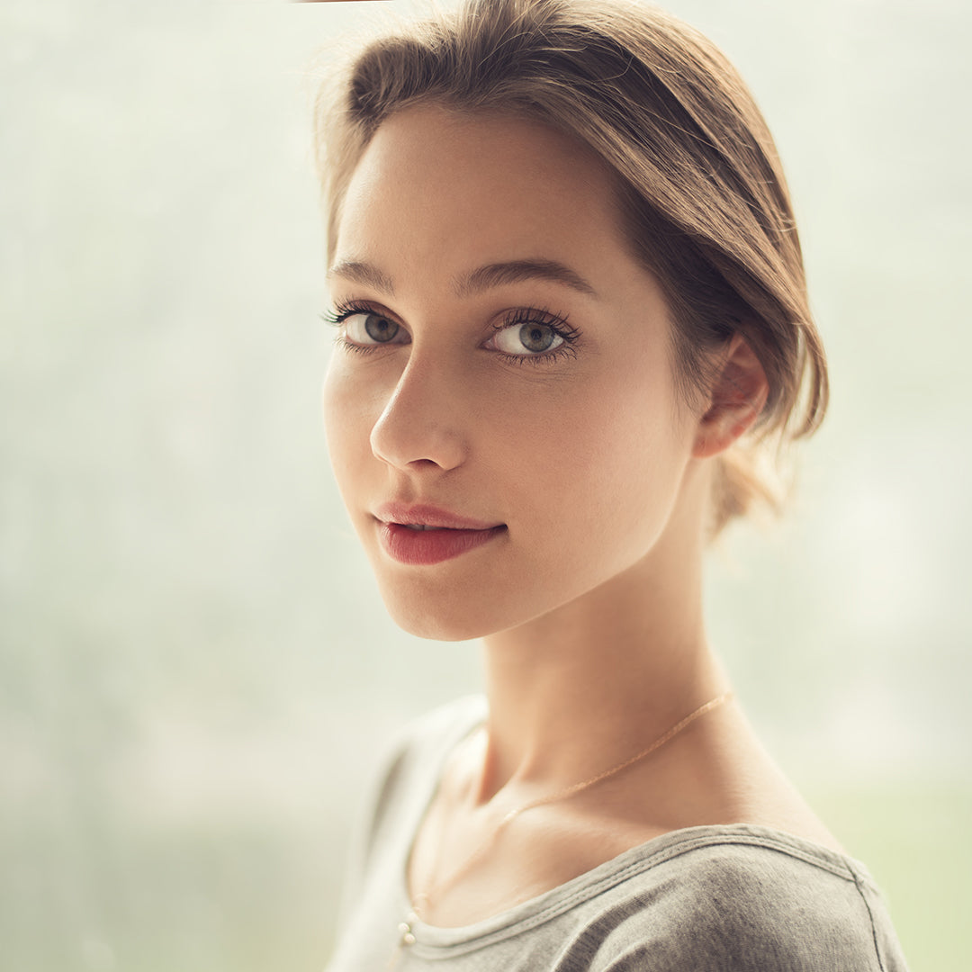 Image of woman with natural and bright-eyed, makeup-less foundation, rosy cheeks, and lips.